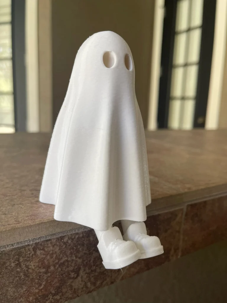 White ghost with hidden legs sitting on the edge of a ledge, legs dangling