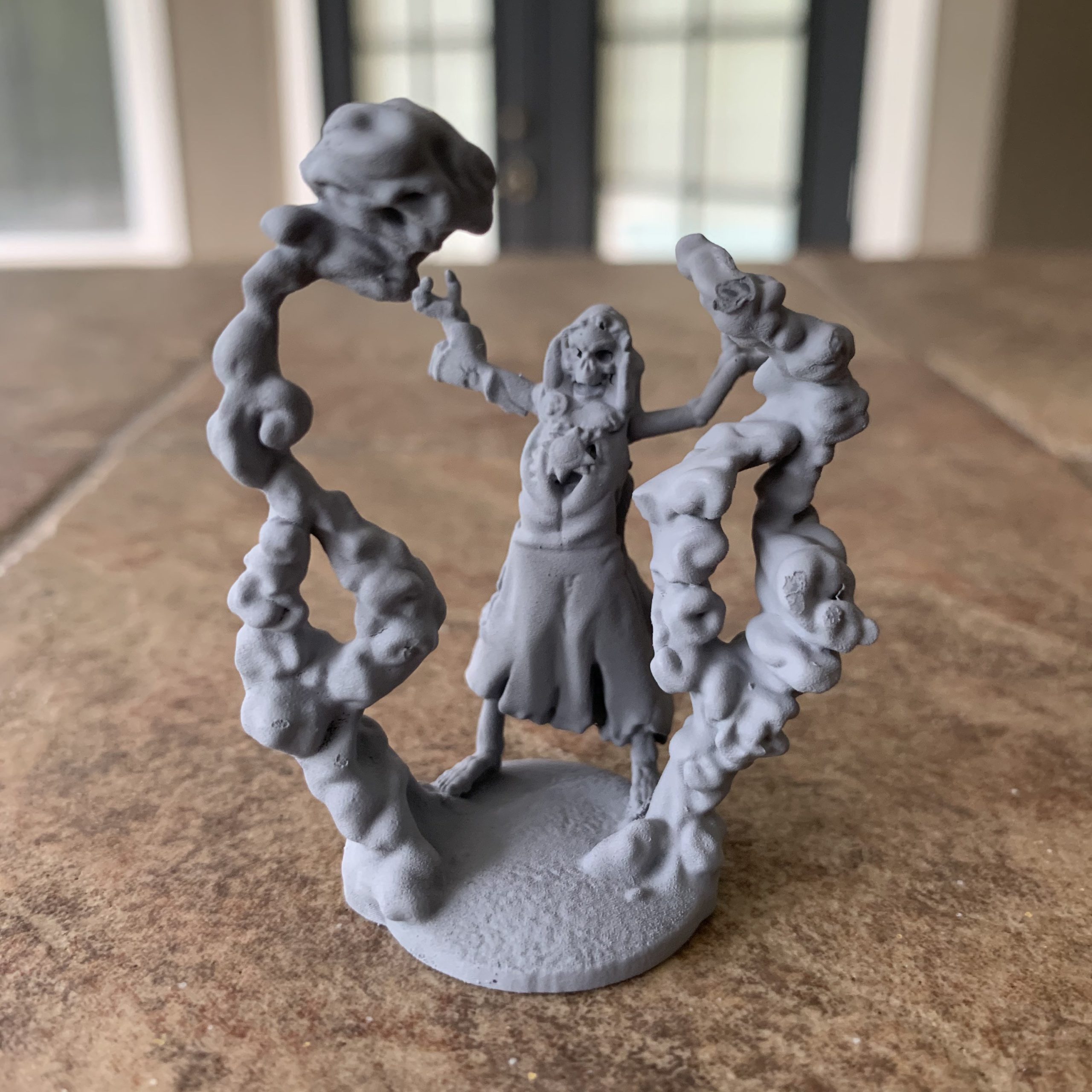 Skeleton necromancer miniature with swirling dark energy and skulls rising from its base