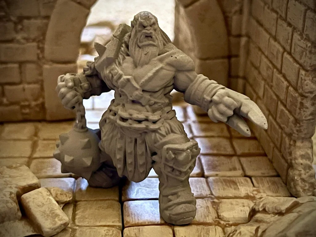 Armored orc war hero miniature with a flail, in a dungeon scene