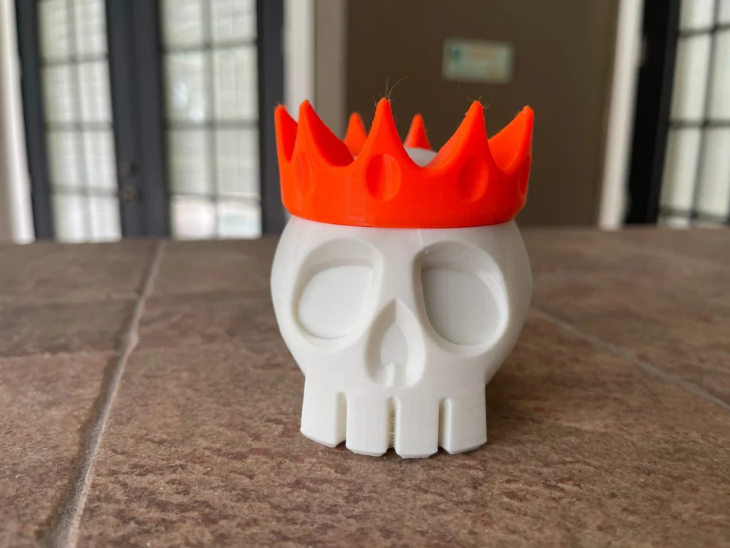 White skull container with an orange crown lid