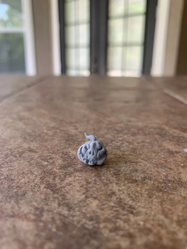 Tiny resin jack-o’-lantern miniature on a tabletop