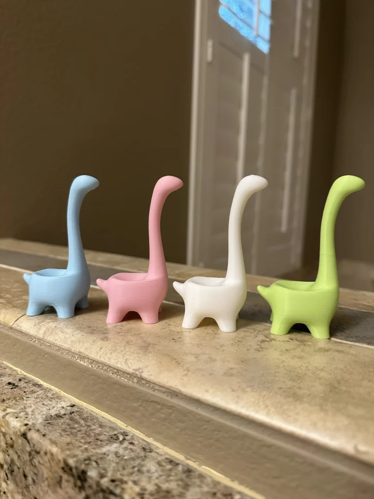 A row of Ringosaurus ring holders in soft colors