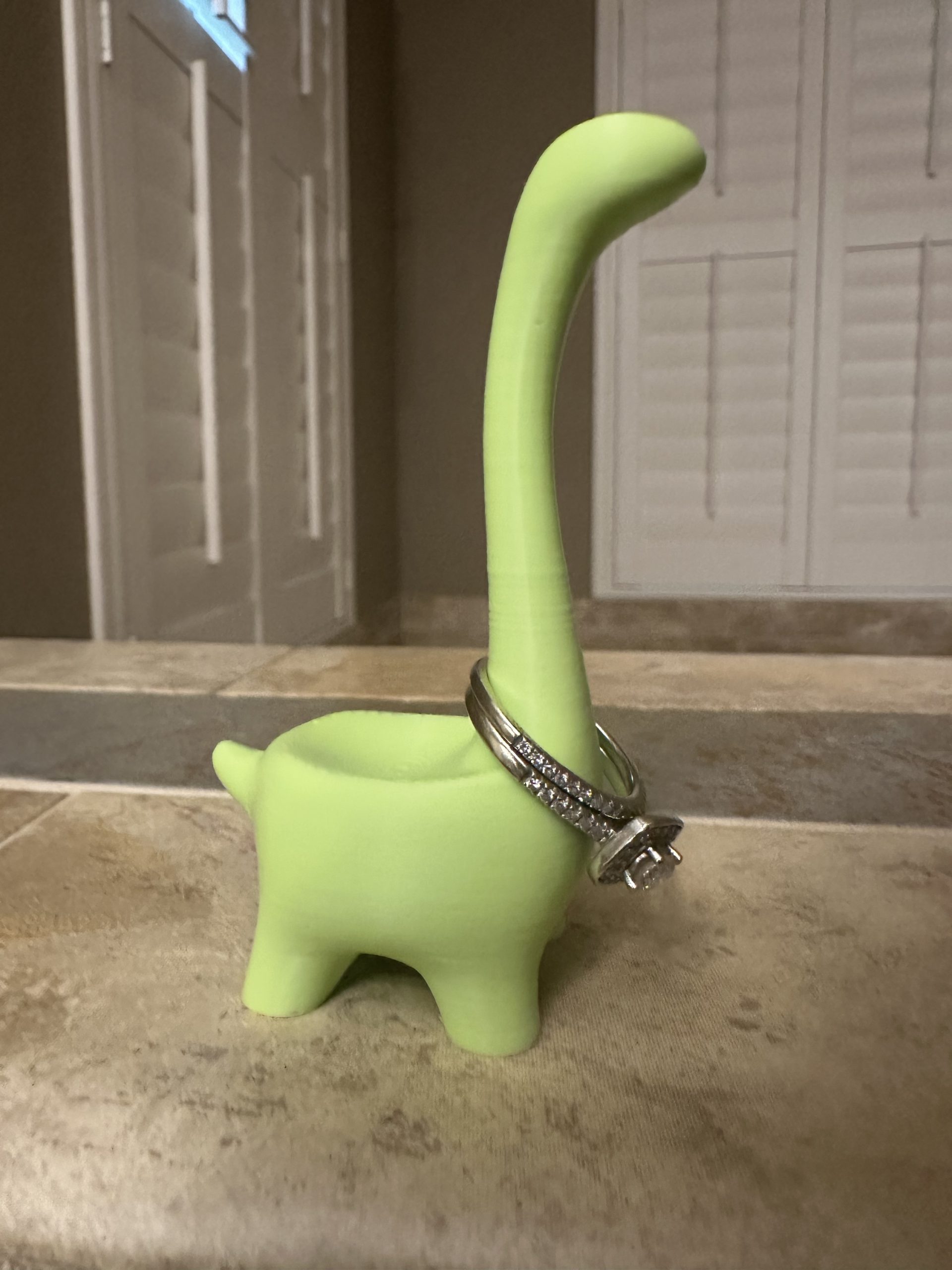 Light green Ringosaurus ring holder with a ring around its neck