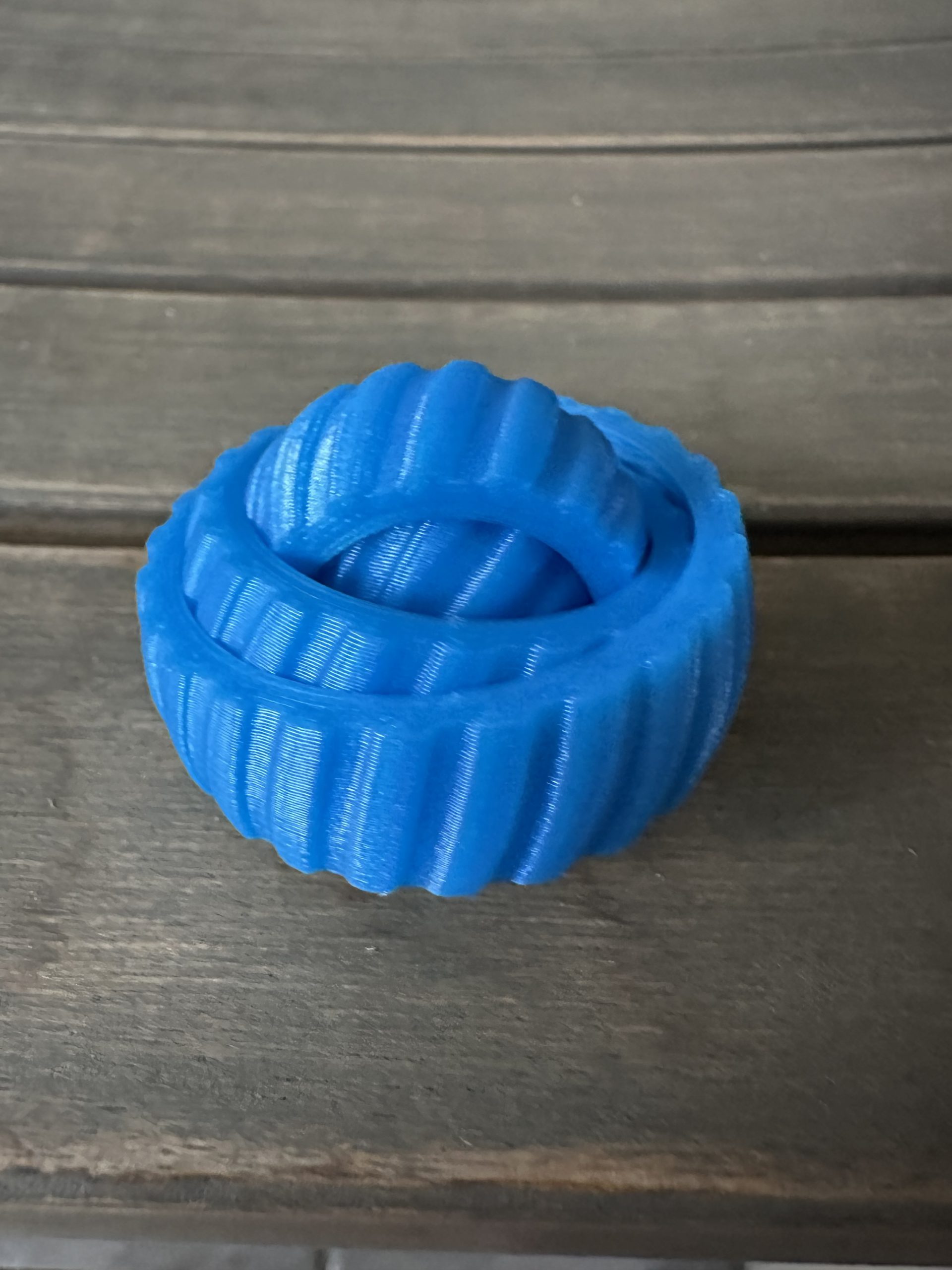 Blue interlocking fidget toy on a wooden table